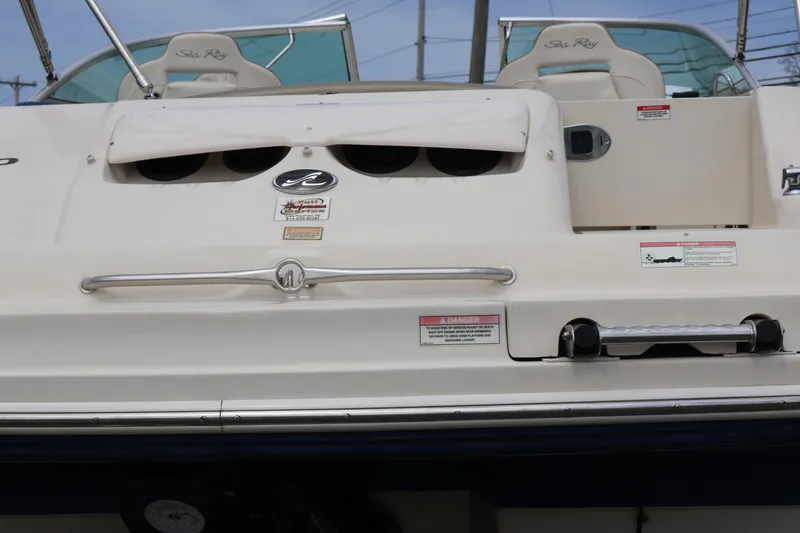 Slide: The Image of 2007 Sea Ray 220 Sundeck boat rear view with seating and safety labels. - 8
