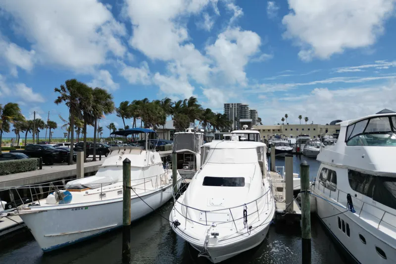 Slide: The Image of 2005 Sea Ray 390 Motor Yacht docked at a marina under a bright blue sky. - 1