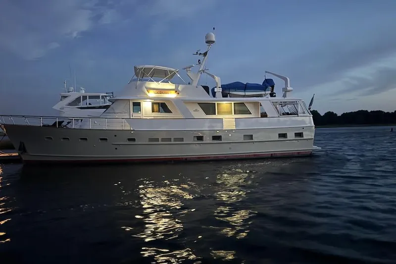 The Image of 1974 Burger 67 Motor Yacht illuminated on calm waters at dusk. - 1