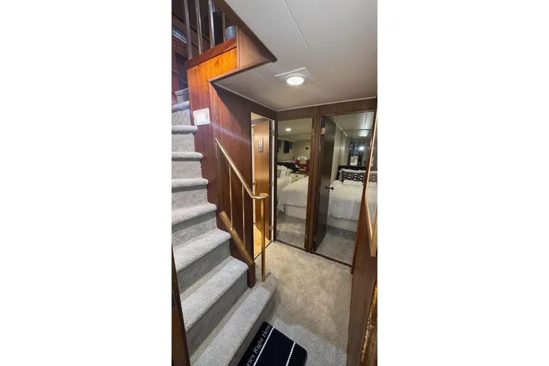 Slide: The Image of Interior of 1974 Burger 67 Motor Yacht with carpeted stairs and mirrored doors. - 16