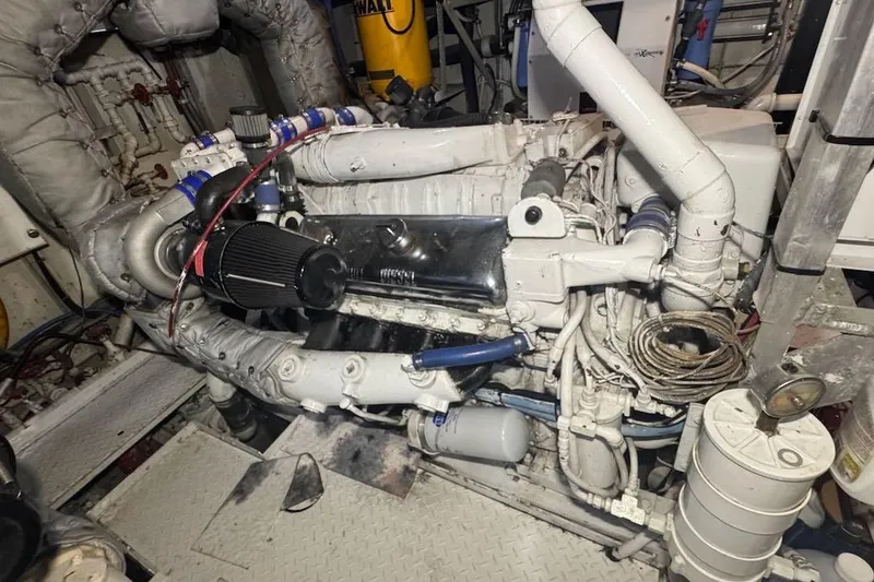 Slide: The Image of Engine room of a 1974 Burger 67 Motor Yacht, showcasing complex machinery and components. - 23