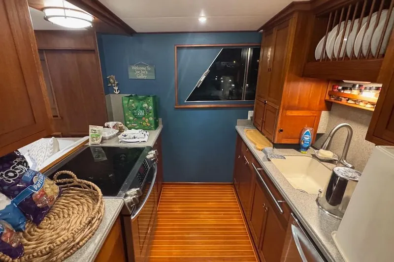 Slide: The Image of Galley kitchen in 1974 Burger 67 Motor Yacht with wooden cabinetry and modern appliances. - 6