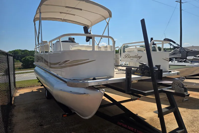 Slide: The Image of 2010 Bentley Pontoons 200 Fish on trailer, featuring canopy and sleek design. - 18