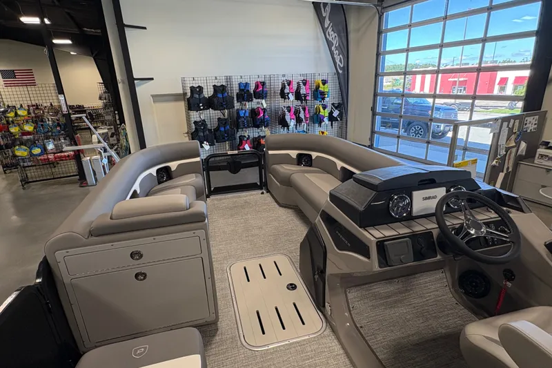 Slide: The Image of 2027 Premier 250 Sunsation RS - CL pontoon boat interior in showroom with seating and steering console. - 17