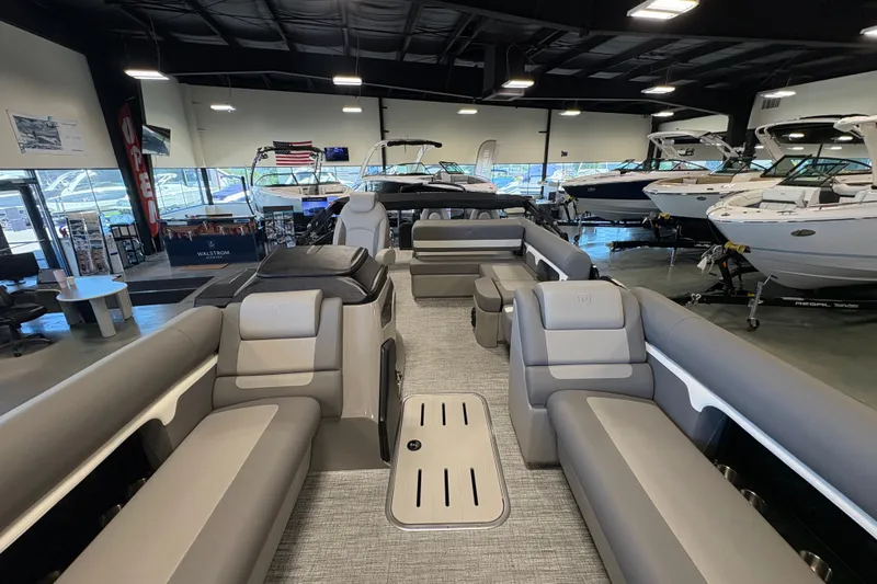 Slide: The Image of 2027 Premier 250 Sunsation RS - CL pontoon boat interior in showroom, featuring spacious seating. - 12