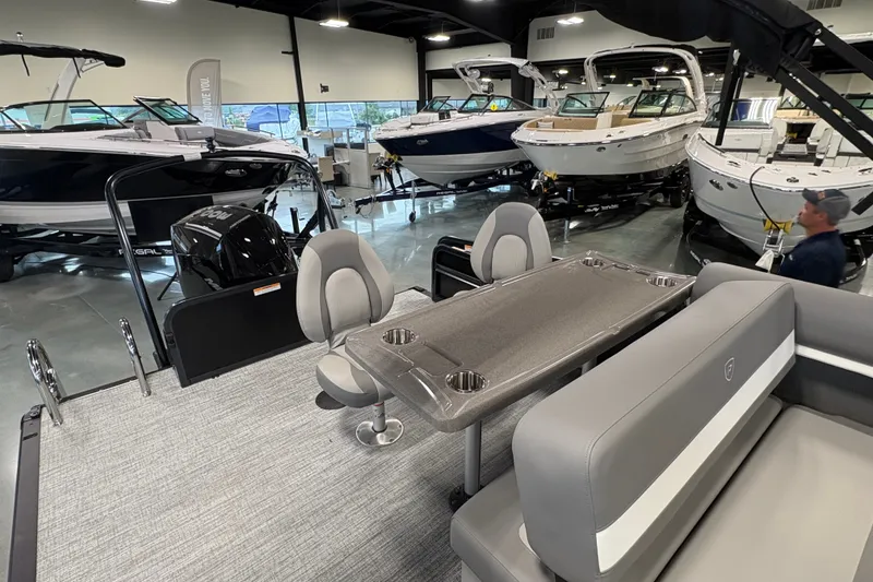 Slide: The Image of 2027 Premier 250 Sunsation RS-CL pontoon boat interior in showroom with other boats. - 19