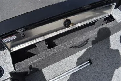 Slide: The Image of 2026 Lowe Fishing Machine 1875 storage compartment with open lid and shadow on deck. - 23