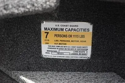 Slide: The Image of 2026 Lowe Fishing Machine 1875 capacity label, 7 persons or 1115 lbs, U.S. Coast Guard compliant. - 40