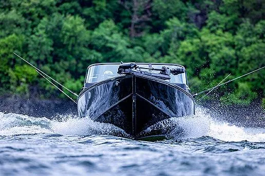 Slide: The Image of Manufacturer Provided Image: 2025 Lowe Fishing Machine 1875 boat navigating through water with lush green forest backdrop. - 43