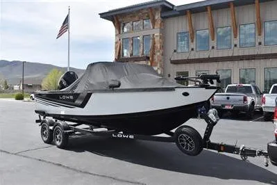Slide: The Image of 2026 Lowe Fishing Machine 1875 boat on trailer, parked outside a building. - 5