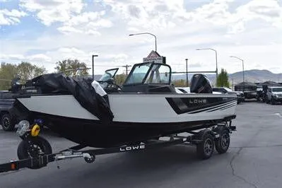 Slide: The Image of 2026 Lowe Fishing Machine 1875 boat on trailer, parked outdoors under cloudy sky. - 7