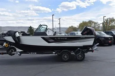 Slide: The Image of 2026 Lowe Fishing Machine 1875 boat on trailer, parked outdoors under cloudy sky. - 8
