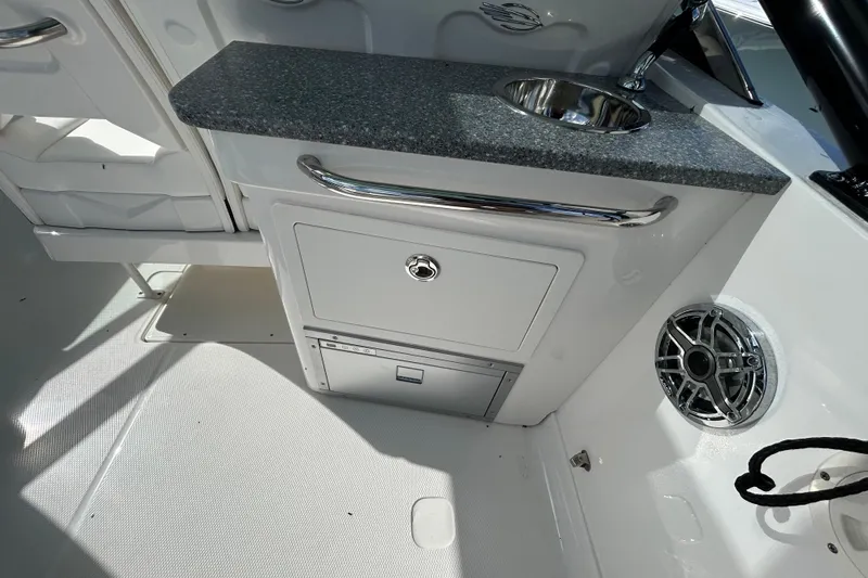 Slide: The Image of 2023 Chaparral 280 OSX boat interior with sink, storage, and speaker. - 12