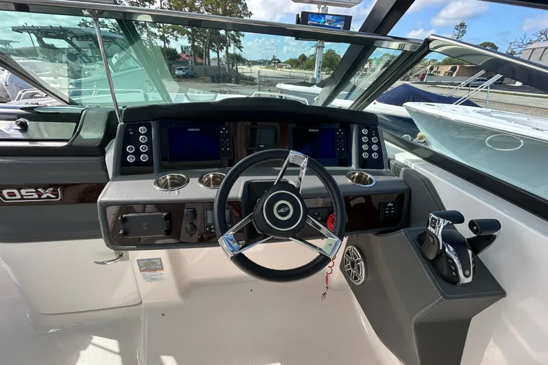 Slide: The Image of 2023 Chaparral 280 OSX boat dashboard with steering wheel and control panel. - 13