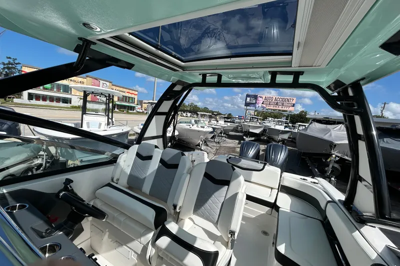 Slide: The Image of 2023 Chaparral 280 OSX boat interior with modern seating and panoramic sunroof. - 16