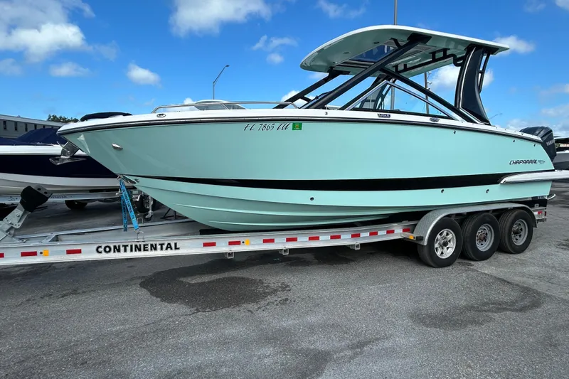Slide: The Image of 2023 Chaparral 280 OSX boat on trailer, parked outdoors under blue sky. - 2