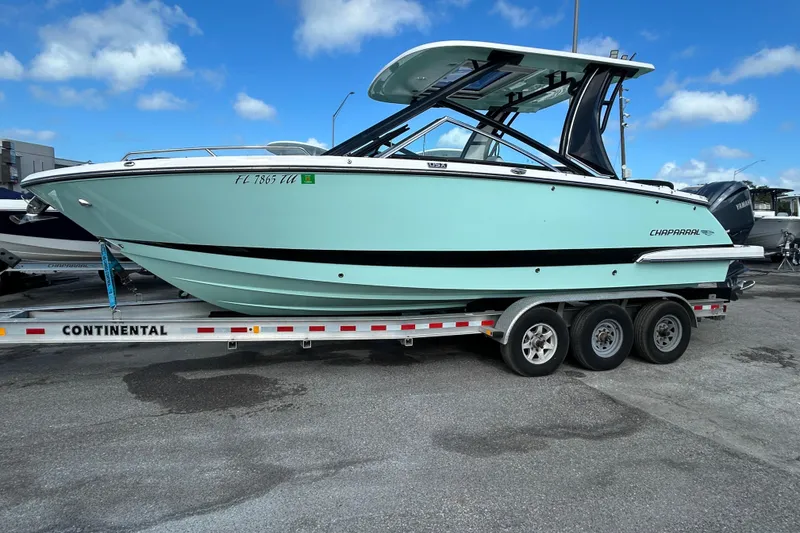 Slide: The Image of 2023 Chaparral 280 OSX boat on trailer under blue sky. - 4