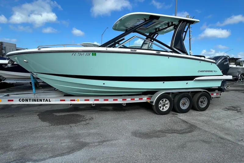 Slide: The Image of 2023 Chaparral 280 OSX boat on trailer under blue sky. - 5