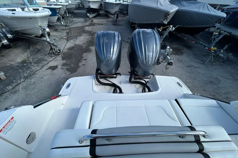 Slide: The Image of 2023 Chaparral 280 OSX boat with dual outboard engines in a marina setting. - 9