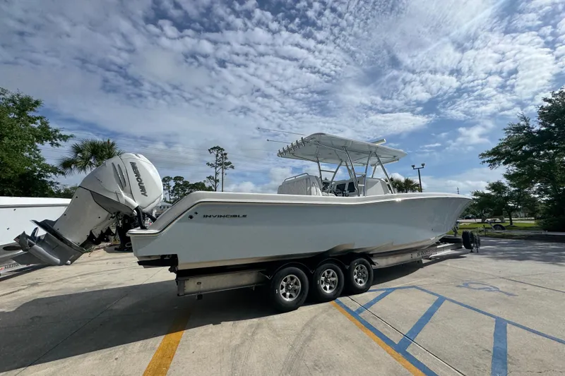 Slide: The Image of 2017 Invincible 39 Open Fisherman boat on trailer, parked outdoors under a cloudy sky. - 10