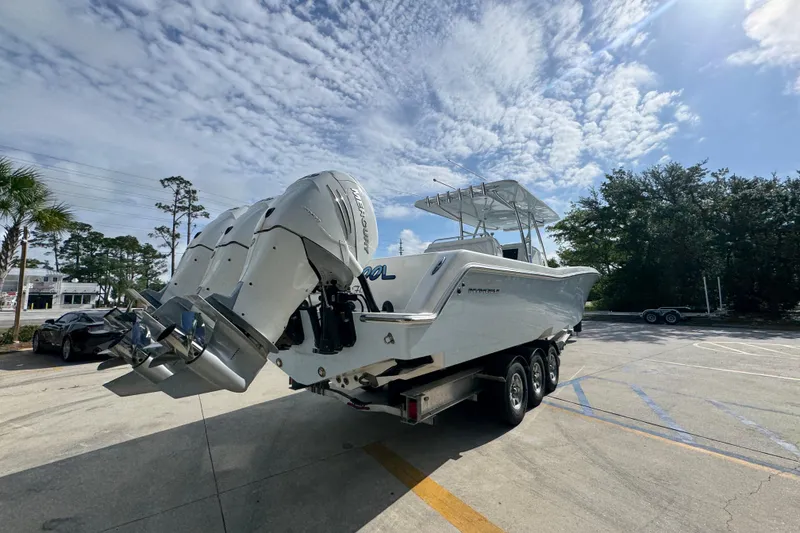 Slide: The Image of 2017 Invincible 39 Open Fisherman boat on trailer, featuring powerful outboard engines. - 11