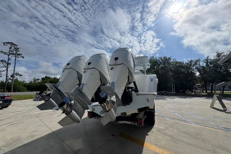 Slide: The Image of 2017 Invincible 39 Open Fisherman with triple outboard engines under a partly cloudy sky. - 12