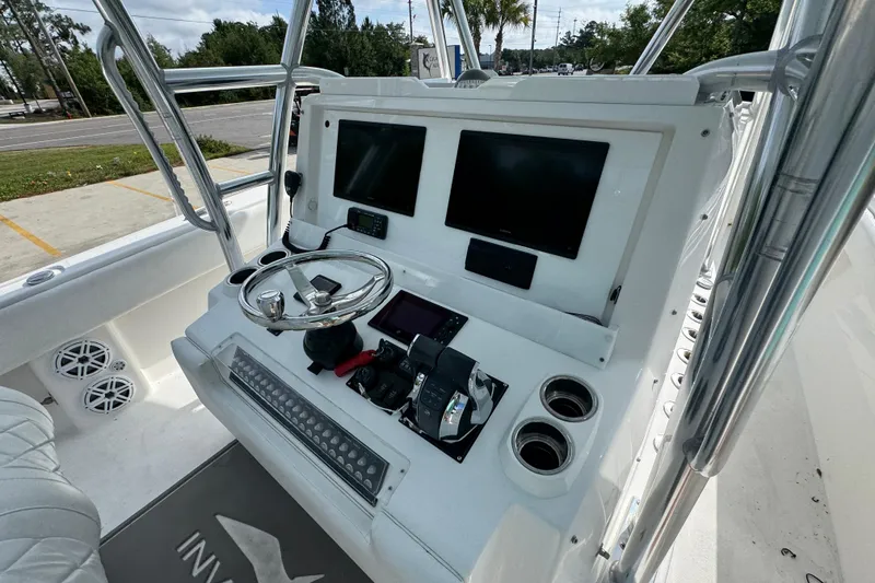 Slide: The Image of 2017 Invincible 39 Open Fisherman boat dashboard with dual screens and steering wheel. - 25