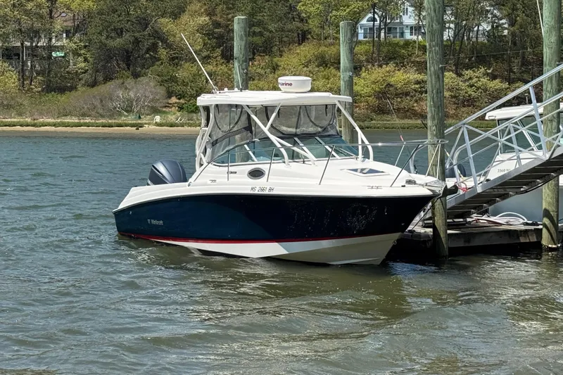 Slide: The Image of 2016 Wellcraft 252 Coastal boat docked by a scenic shoreline. - 2
