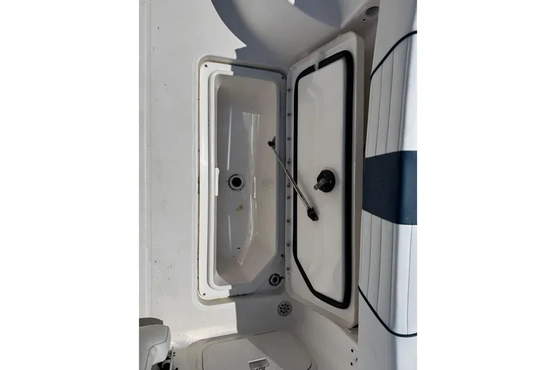 Slide: The Image of 2016 Wellcraft 252 Coastal boat storage compartment with open hatch, showcasing interior details. - 21