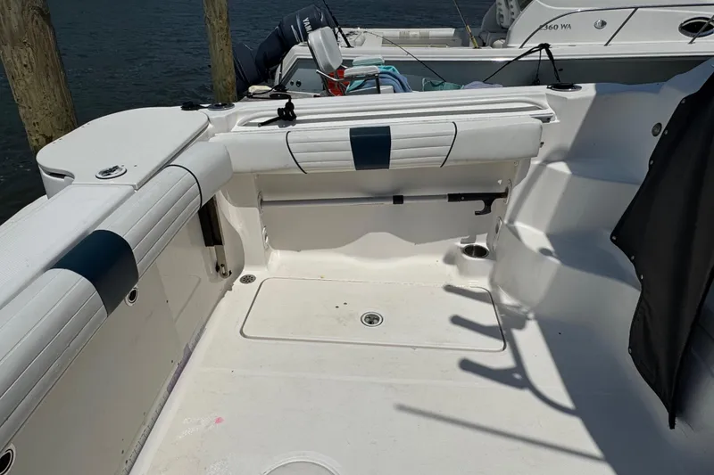 Slide: The Image of 2016 Wellcraft 252 Coastal boat interior with white seating and storage compartments. - 27