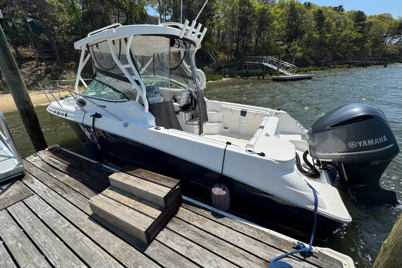 Slide: The Image of 2016 Wellcraft 252 Coastal boat docked with Yamaha outboard motor, surrounded by water and trees. - 3