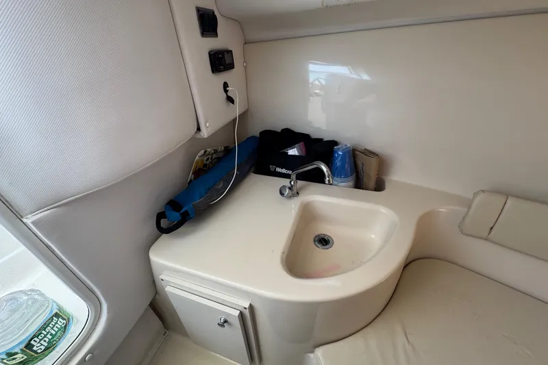 Slide: The Image of Interior of 2016 Wellcraft 252 Coastal boat featuring a compact sink and storage area. - 34