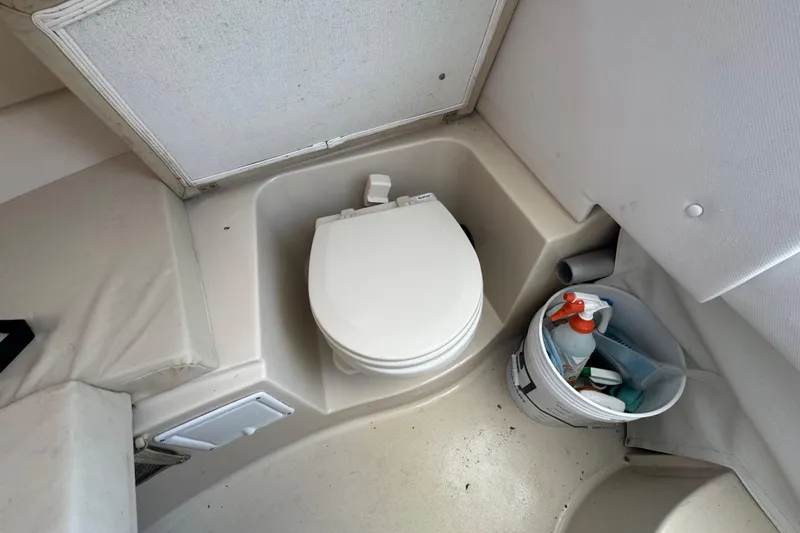 Slide: The Image of 2016 Wellcraft 252 Coastal boat interior with compact toilet and cleaning supplies. - 36