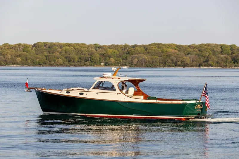 The Image of Hinckley Picnic Boat 36 Classic, 2000 model, cruising on calm waters with lush green shoreline. - 1