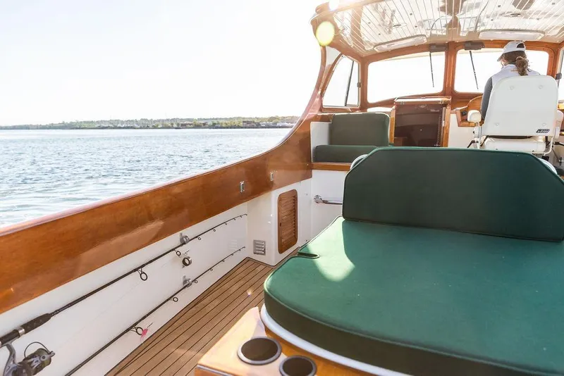 Slide: The Image of Hinckley Picnic Boat 36 Classic, 2000 model, featuring elegant wooden interior and green seating. - 11