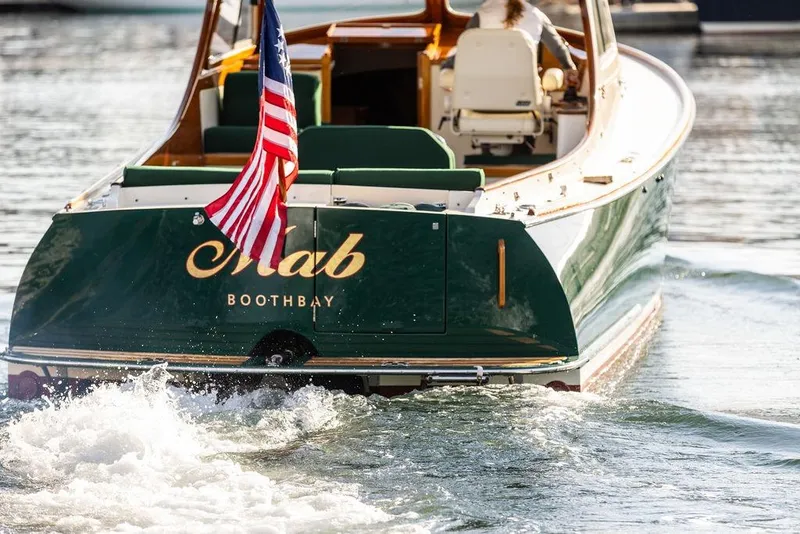 Slide: The Image of Hinckley Picnic Boat 36 Classic, 2000 model, cruising with American flag on water. - 4