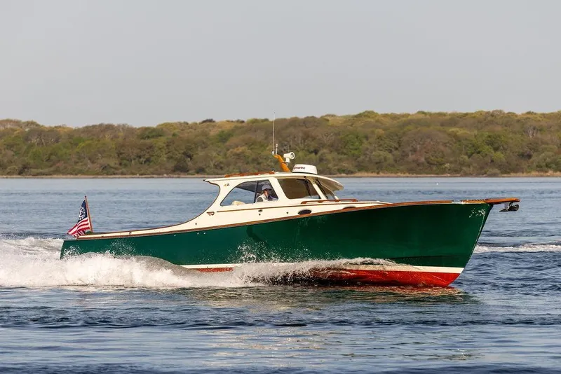 Slide: The Image of Hinckley Picnic Boat 36 Classic, 2000 model, cruising on calm waters with scenic backdrop. - 5
