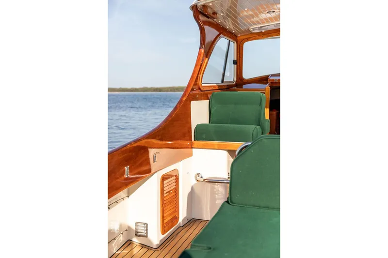 Slide: The Image of Hinckley Picnic Boat 36 Classic 2000 interior with green seating and wooden accents. - 9