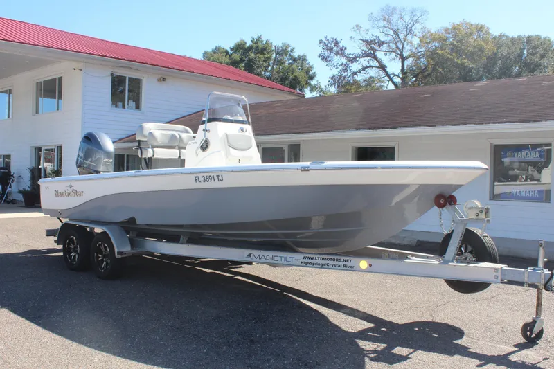 Slide: The Image of 2022 NauticStar 227 Bay boat on trailer, parked outside a building. - 11
