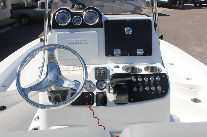 Slide: The Image of 2022 NauticStar 227 Bay boat dashboard with steering wheel and control panel. - 16