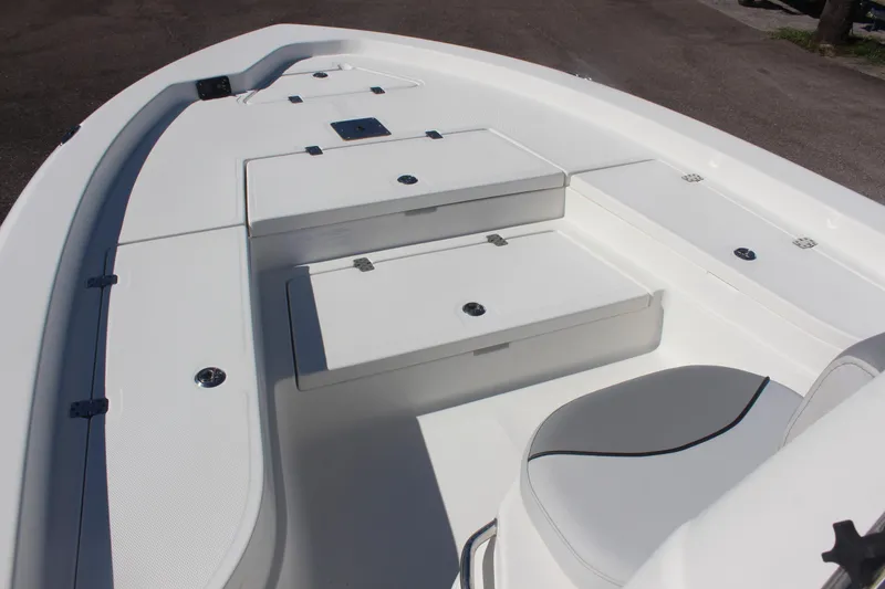 Slide: The Image of 2022 NauticStar 227 Bay boat interior with white seating and storage compartments. - 19