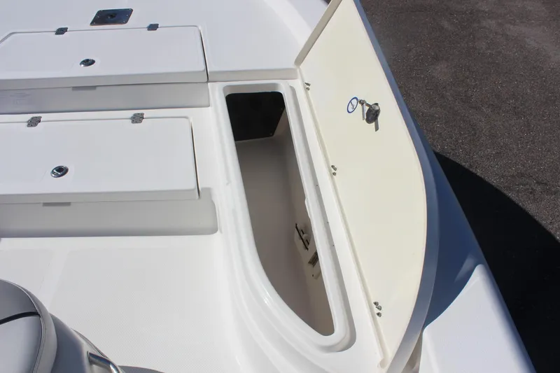Slide: The Image of 2022 NauticStar 227 Bay boat storage compartment with open hatch and key. - 20