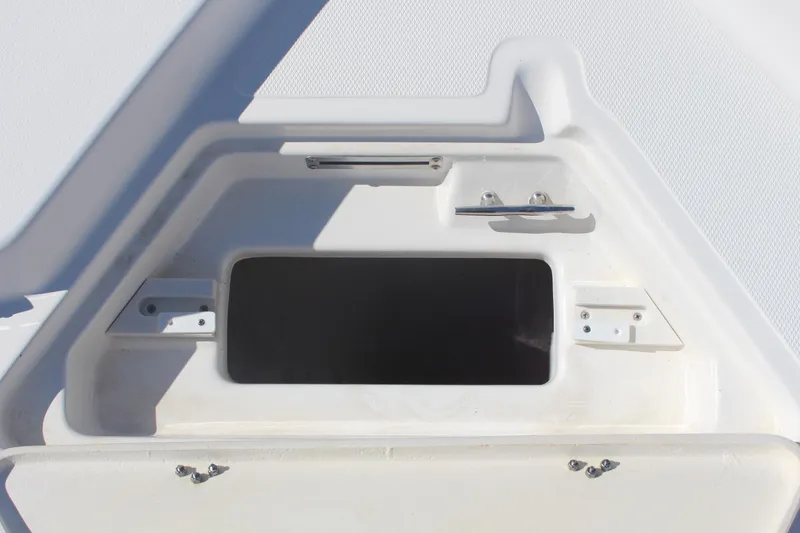 Slide: The Image of 2022 NauticStar 227 Bay boat storage compartment with open hatch, showcasing interior space. - 25