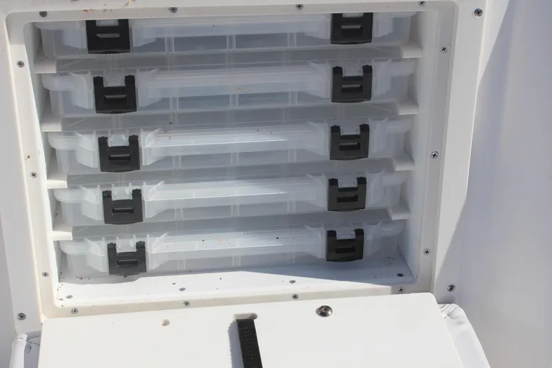 Slide: The Image of Storage compartments on a 2022 NauticStar 227 Bay boat, featuring organized tackle trays. - 28