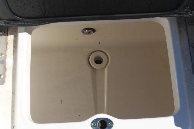 Slide: The Image of Livewell compartment in a 2022 NauticStar 227 Bay boat, featuring a drainage hole. - 34