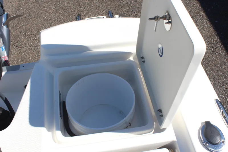 Slide: The Image of Open storage compartment on 2022 NauticStar 227 Bay boat, featuring a white bucket inside. - 36