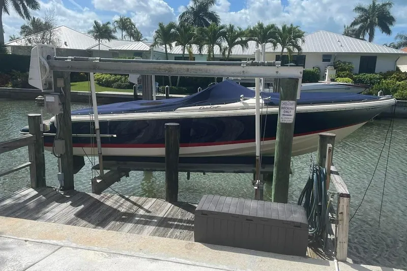Slide: The Image of 2011 Chris-Craft Launch 22 Heritage Edition boat docked on a lift by waterfront homes. - 1