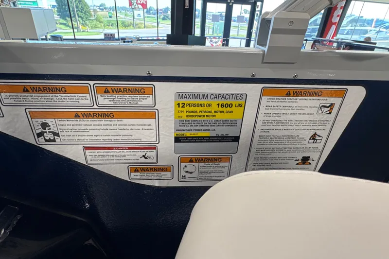 Slide: The Image of Warning labels and capacity information on a 2027 Premier 200 Sunscape RL - CL boat. - 13