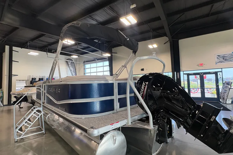 Slide: The Image of 2027 Premier 200 Sunscape RL - CL pontoon boat displayed indoors with Mercury outboard motor. - 4