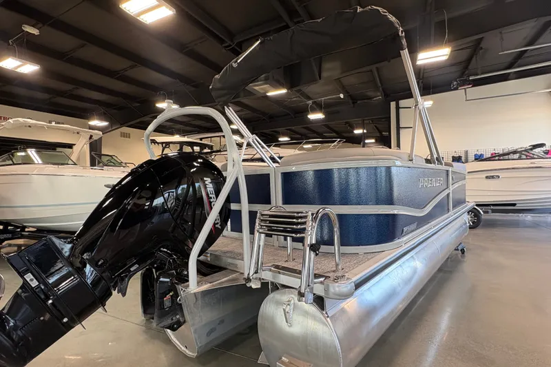Slide: The Image of 2027 Premier 200 Sunscape RL - CL pontoon boat with Mercury outboard motor in showroom. - 3